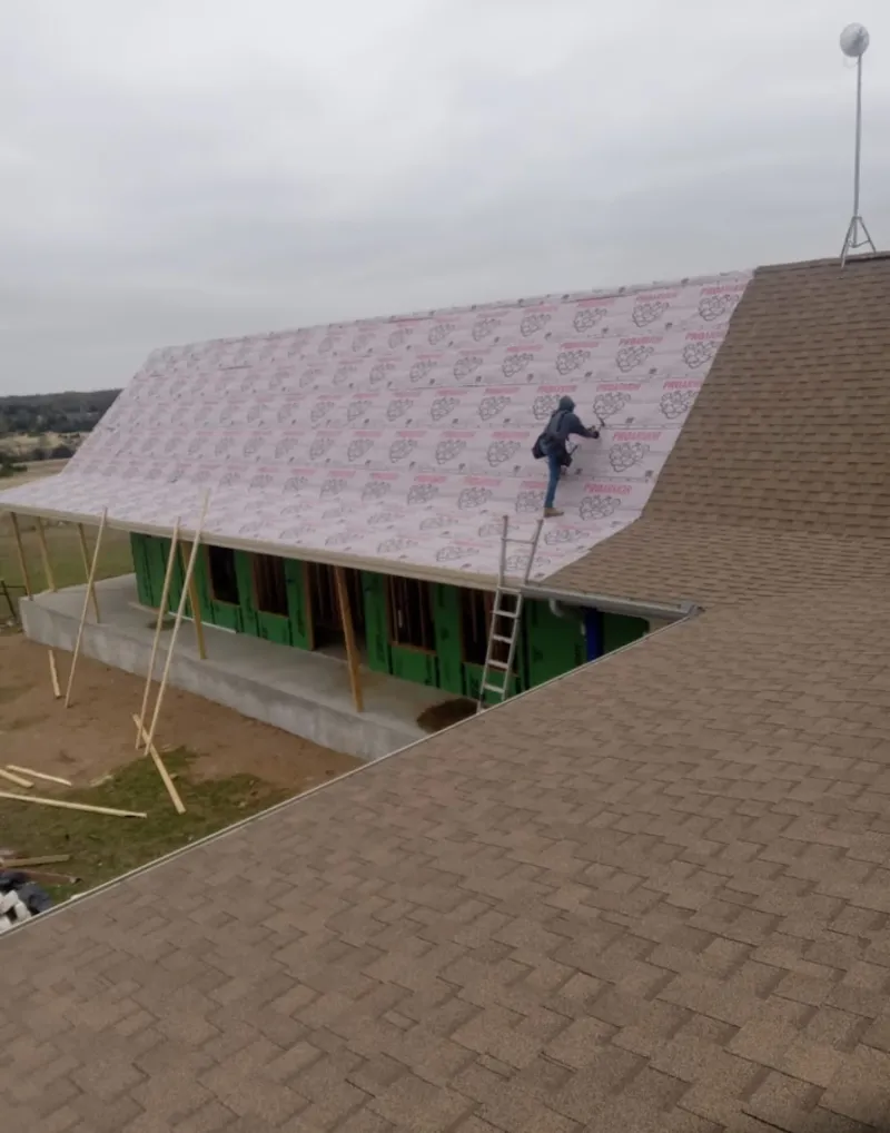 Worker preparing underlayment for a metal roof installation in Long Beach